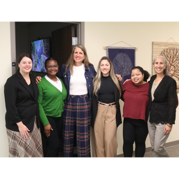 Six members of the Wilson Family Justice Clinic team sit together for a photo. 