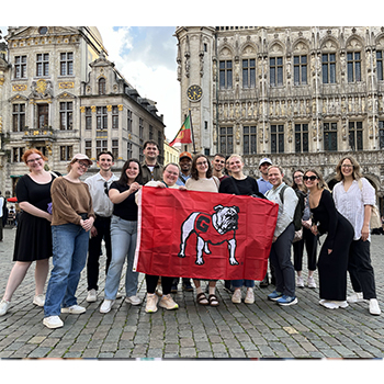 participants in the Global Governance Summer School hold a Georgia Bulldog flag
