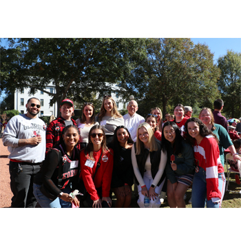 Prof Wells at homecoming BBQ with a group of students